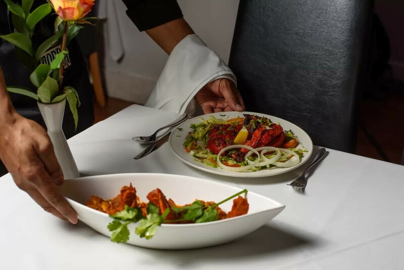 Serving tandoori dishes at The Gandhi restaurant in Gravesend, showcasing vibrant Punjabi flavours and elegant presentation.